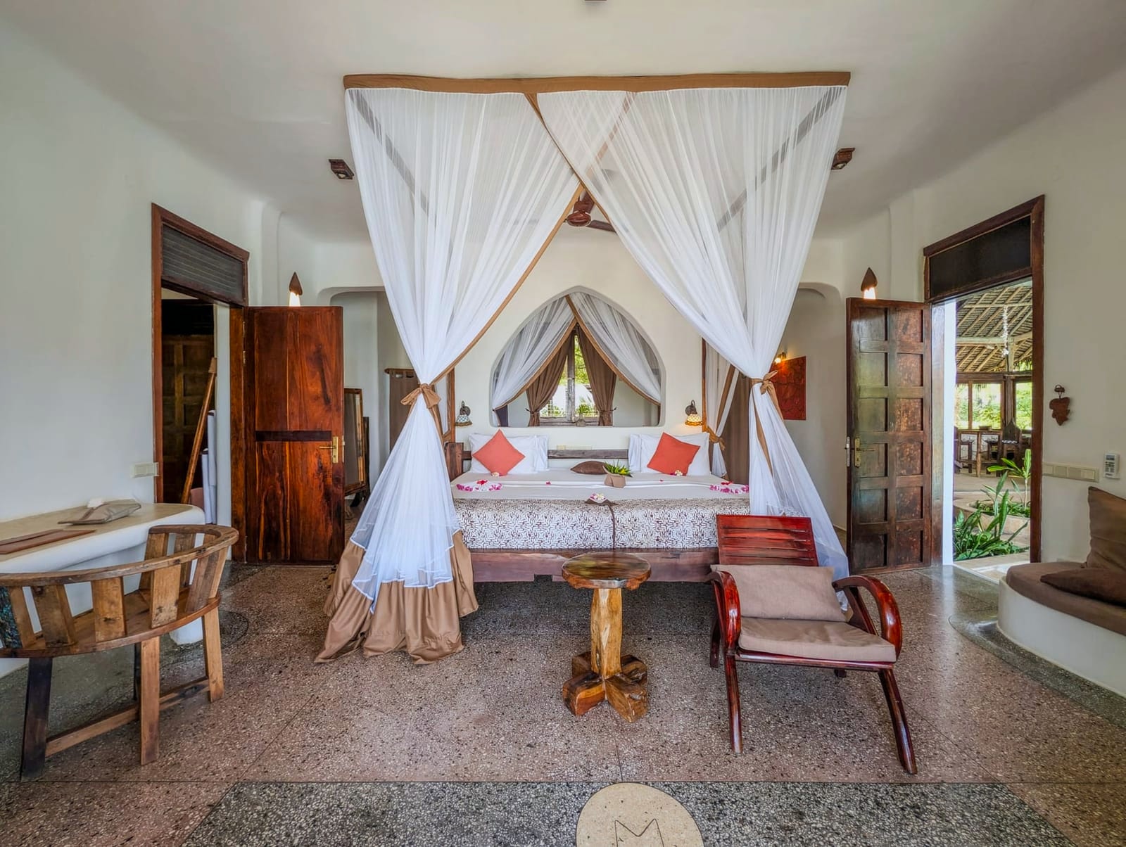 Dunia at Asili House: a four-poster under a mosquito net, doors open to the garden.