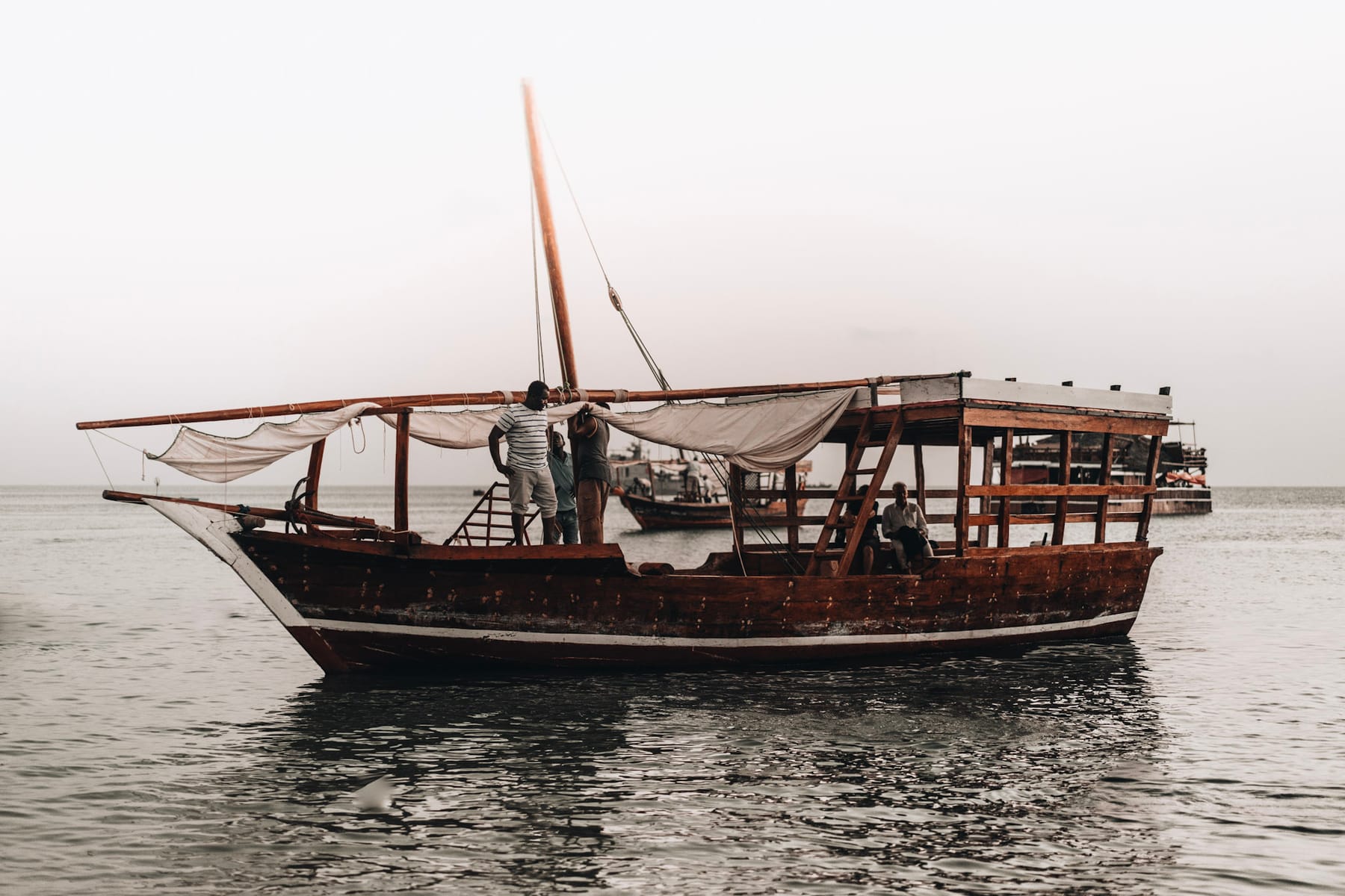 Traditional dhow under sail with passengers on the water off Zanzibar