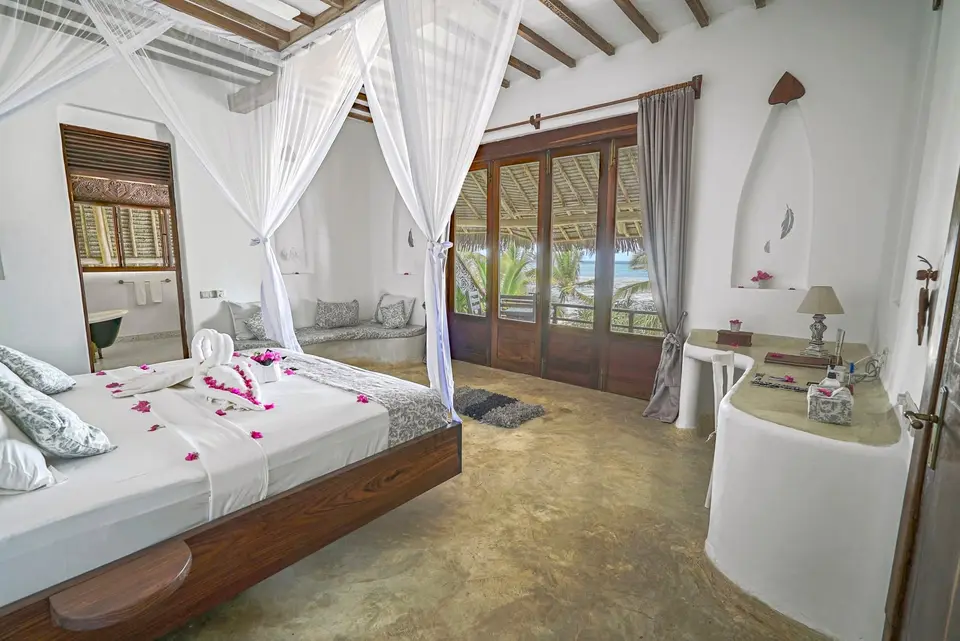Room Hewa during daylight at Asili House, Boutique Hotel Matlai Zanzibar, showing bed, baraza seating, and balcony.