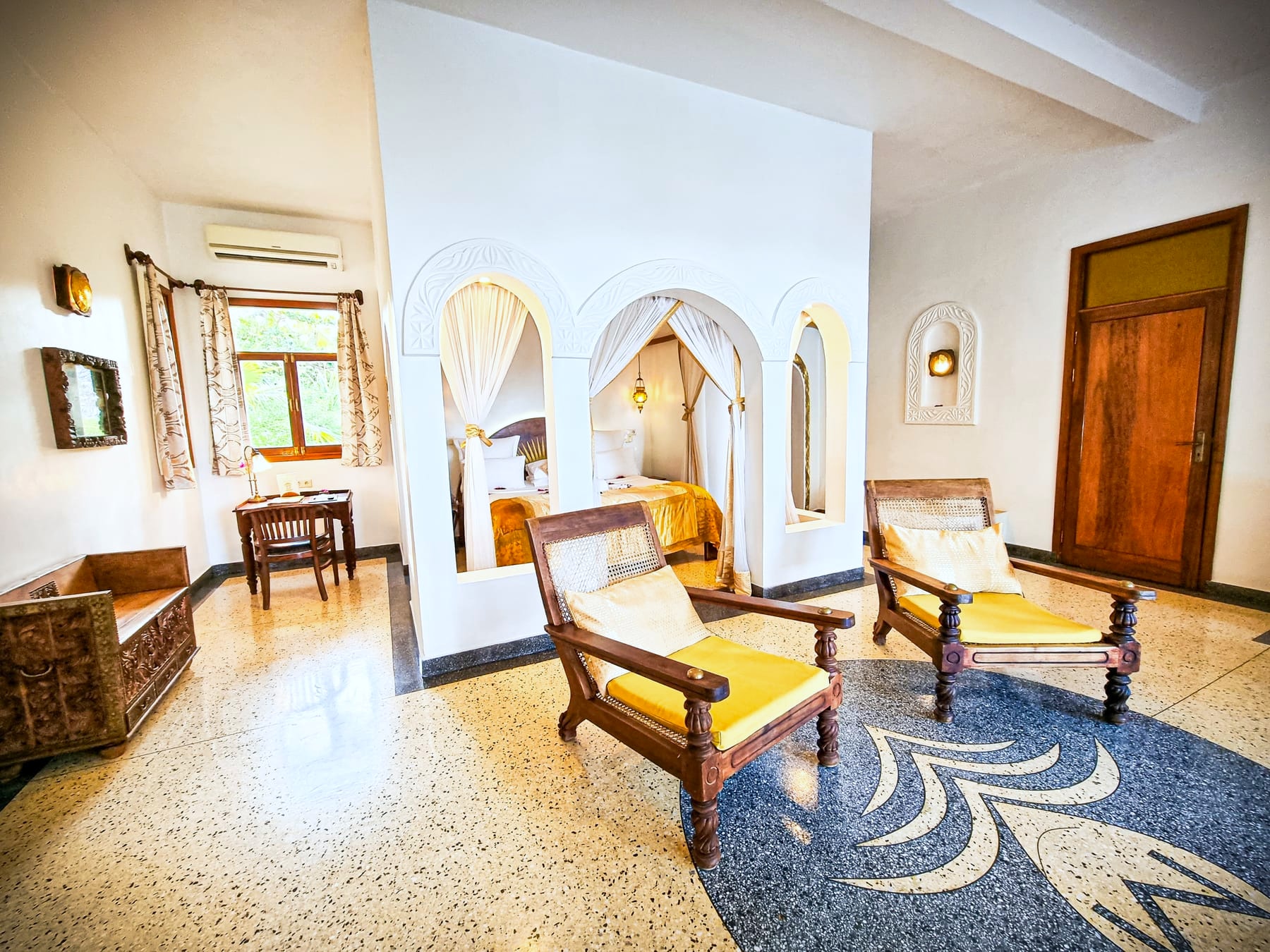 Jua at Villa Kidosho: a carved four-poster bed against white walls.