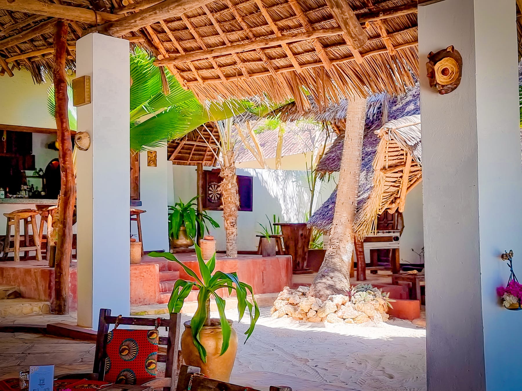 The bar at Zatiny under its makuti roof, with sand underfoot.